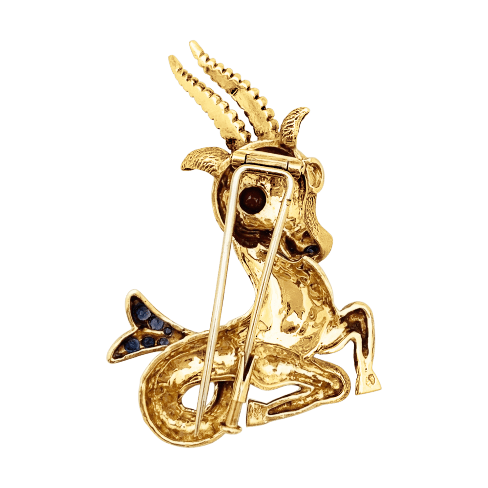 Broche-clip, "Capricorne", or jaune, rubis, saphirs.