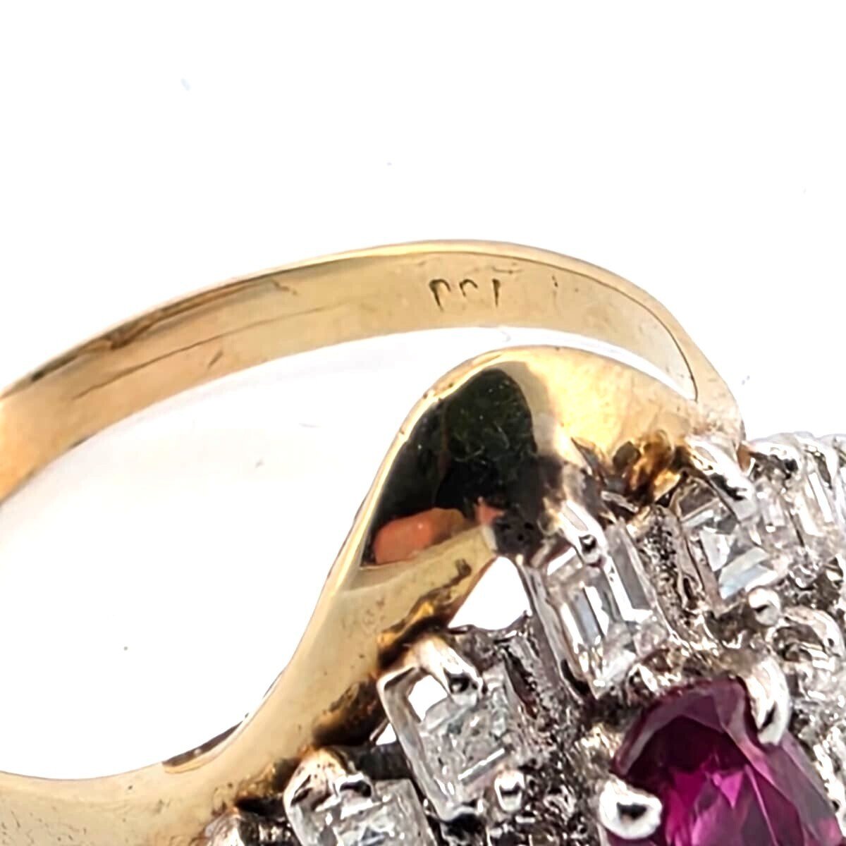 18-karat yellow gold ring with a central ruby and diamonds surrounding it