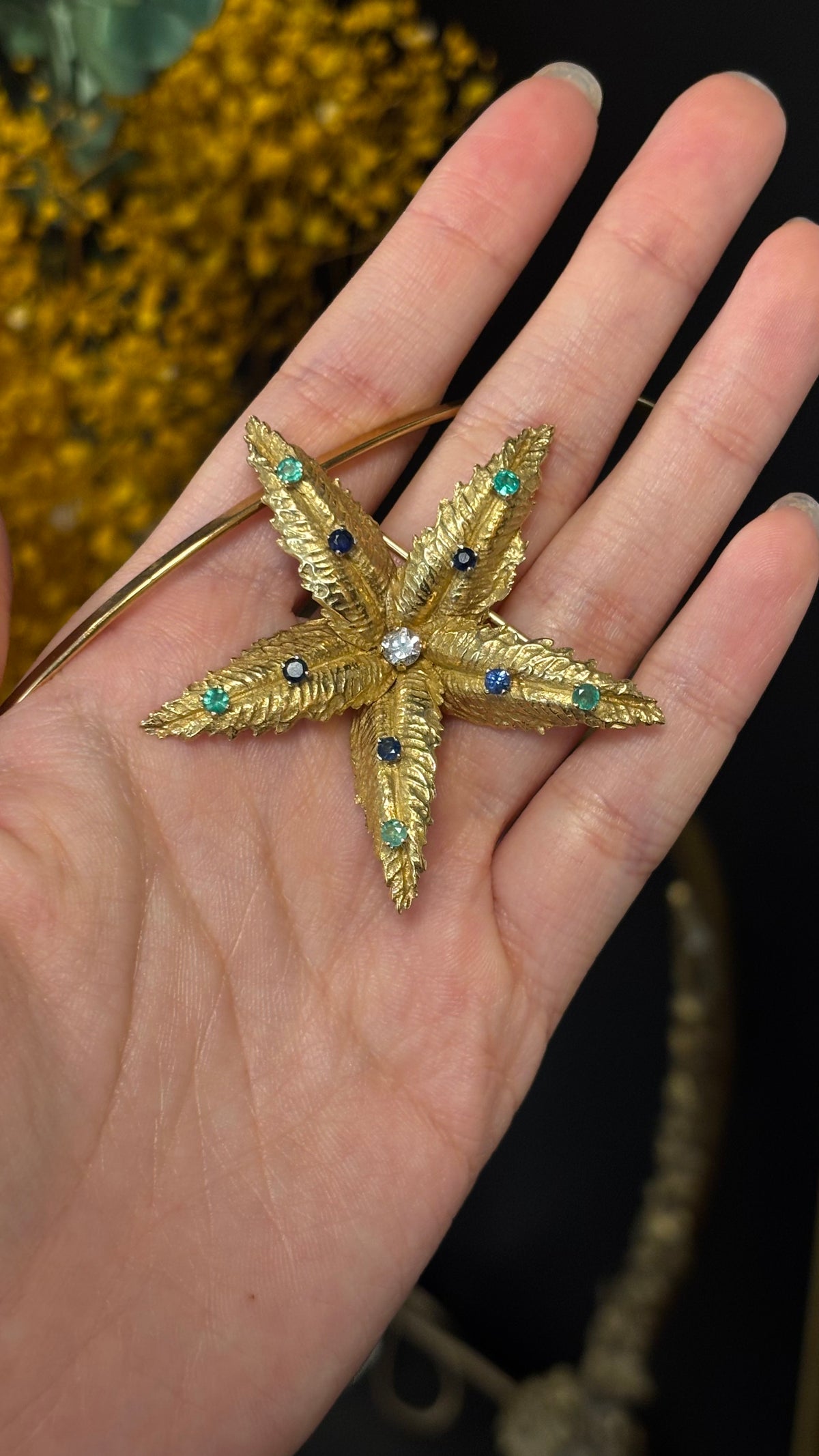 BOUCHERON brooch in yellow gold, emeralds, sapphires, and diamonds