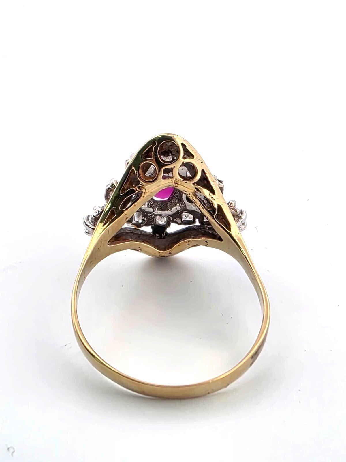 18-karat yellow gold ring with a central ruby and diamonds surrounding it