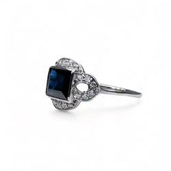 Bague Art - Deco en platine centrée d’un saphir dans un entourage de diamants. - Castafiore