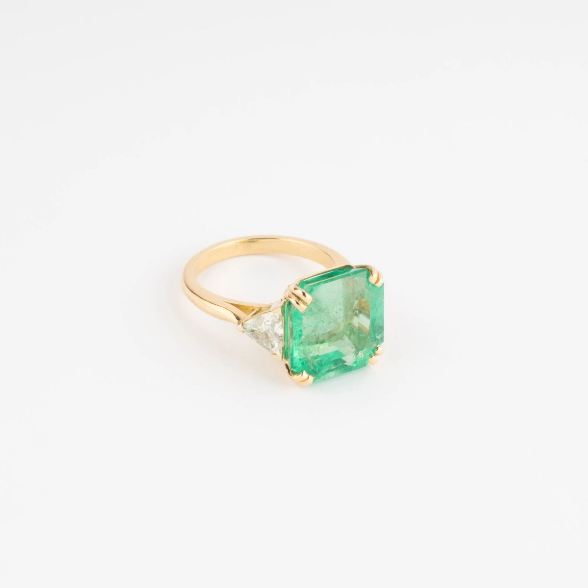 Bague en or jaune ornée d'une émeraude taille émeraude épaulé de diamants triangles - Castafiore