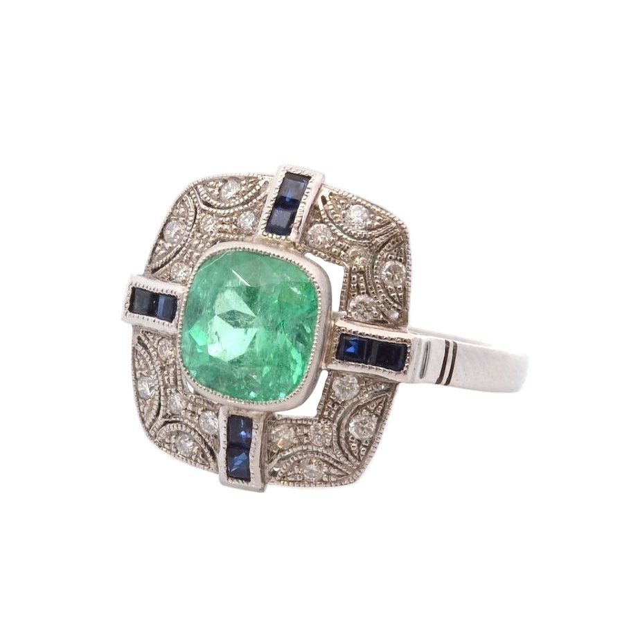 Bague Entourage en platine, émeraude, diamants, et saphirs - Castafiore