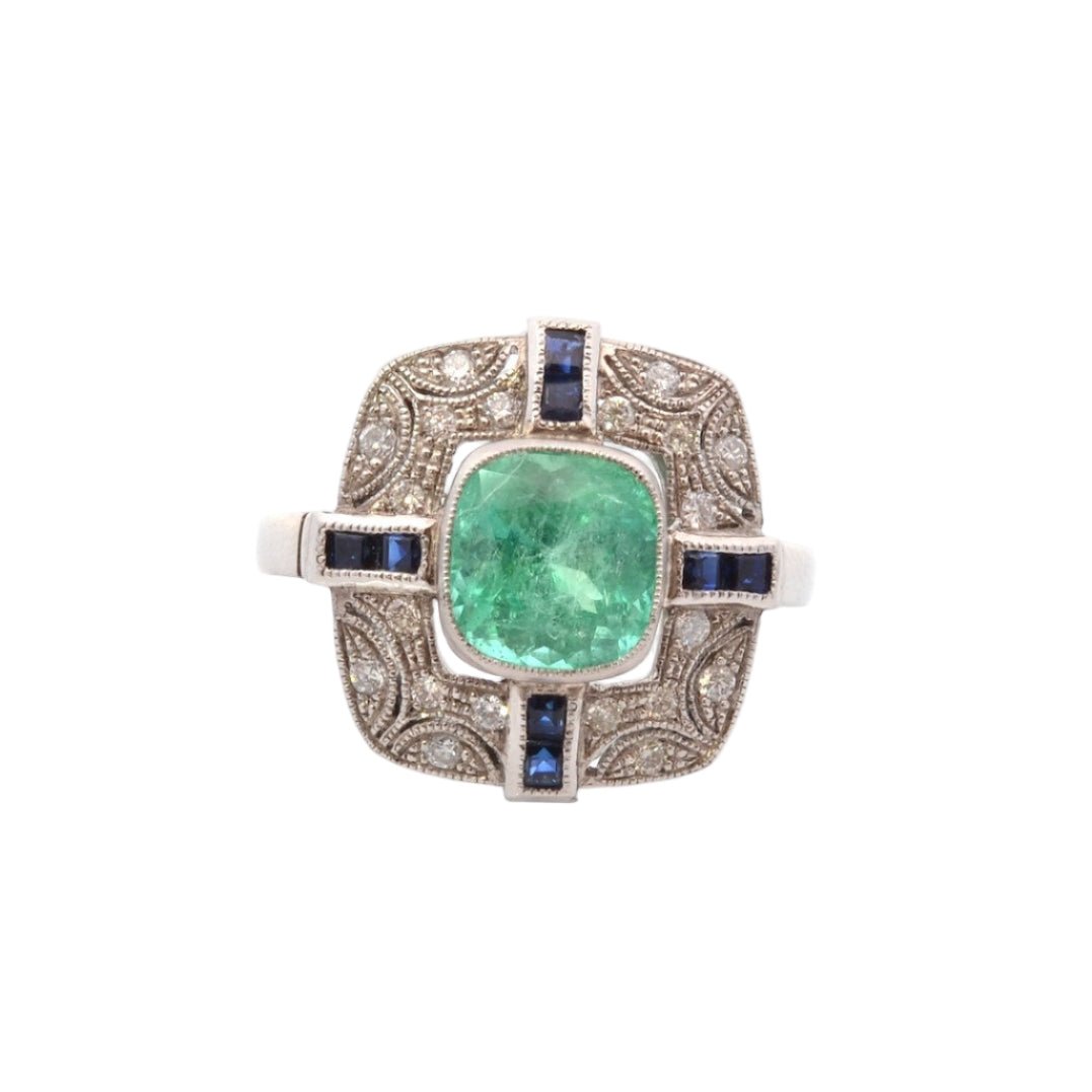 Bague Entourage en platine, émeraude, diamants, et saphirs - Castafiore