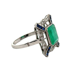 Bague Entourage en platine, émeraude, saphirs et diamants - Castafiore