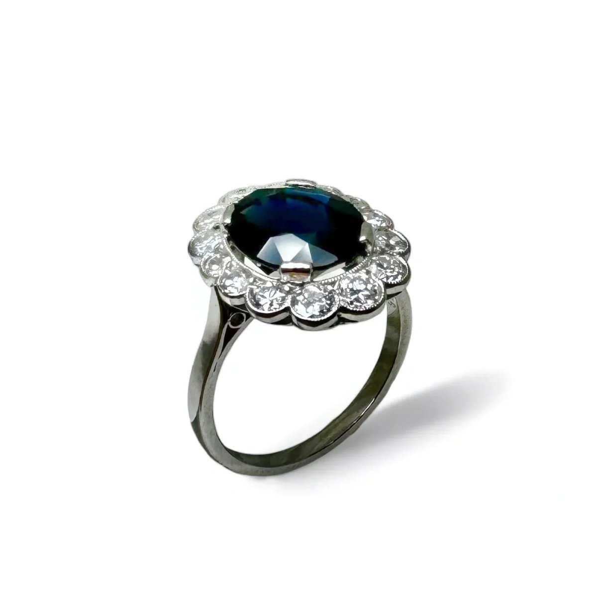 Bague marguerite en platine centrée d’un saphir entouré de diamants. - Castafiore