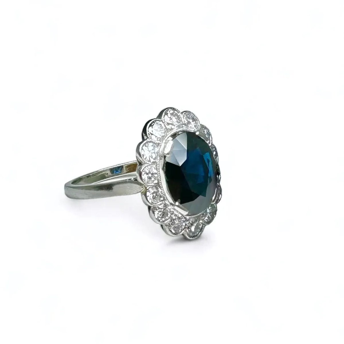 Bague marguerite en platine centrée d’un saphir entouré de diamants. - Castafiore