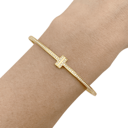 Bracelet Tiffany & Co., "Tiffany T" en or jaune et diamants. - Castafiore