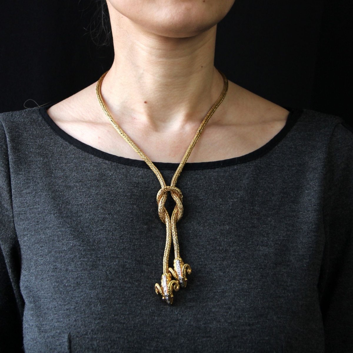 Necklace in braided gold with ram's head motifs diamonds and rubies