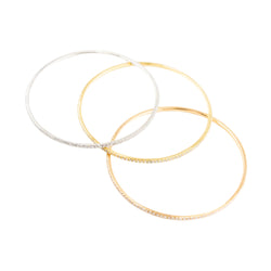 Three bangle bracelets in white gold, yellow gold, rose gold, and diamonds