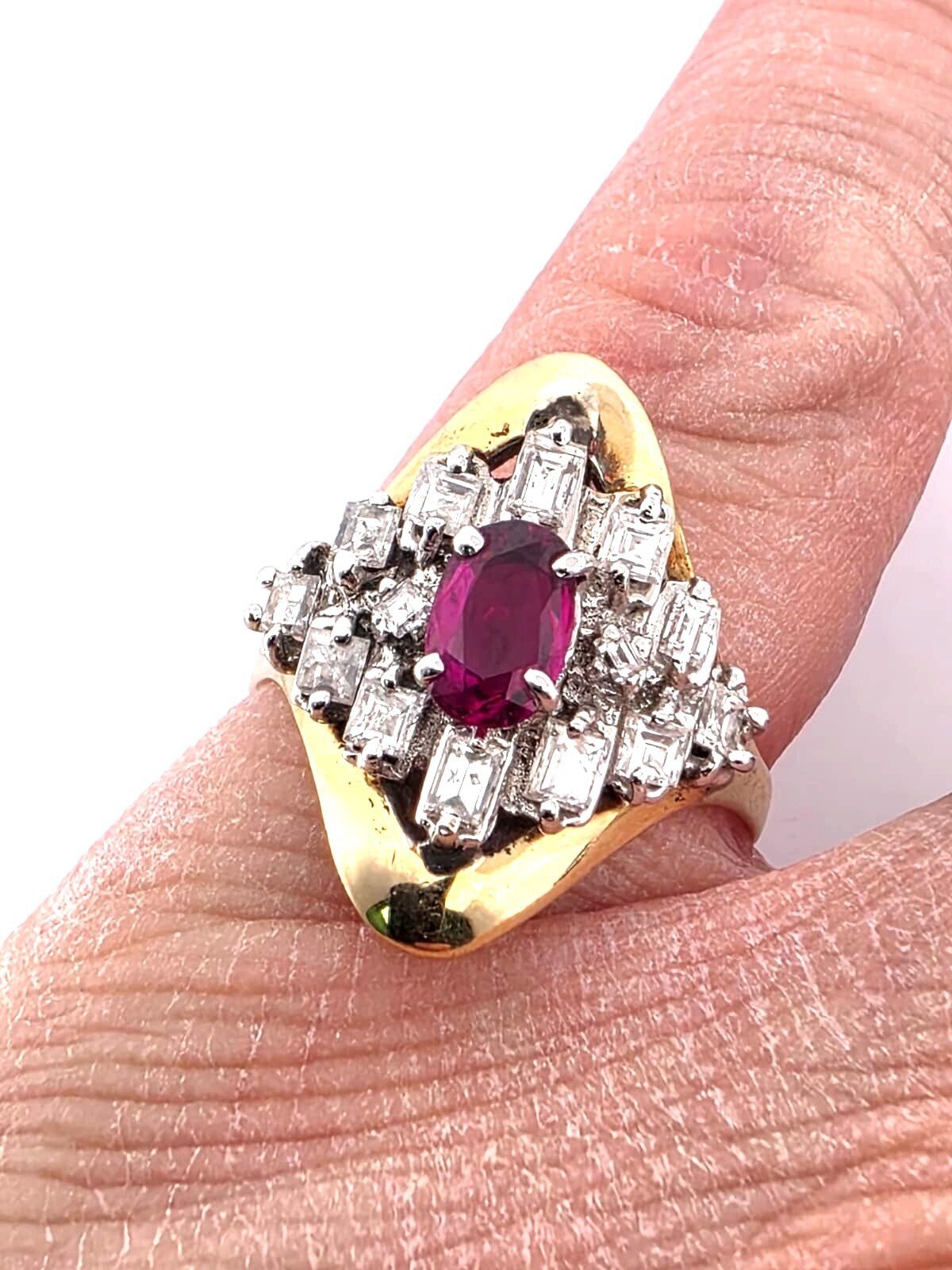 18-karat yellow gold ring with a central ruby and diamonds surrounding it
