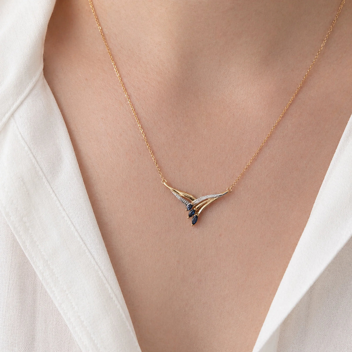 Necklace with a pendant in white gold, yellow gold, sapphires, and a diamond