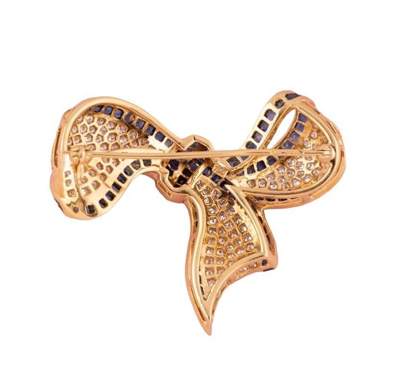 Broche nœud composée d'or jaune 18k saphirs et diamants