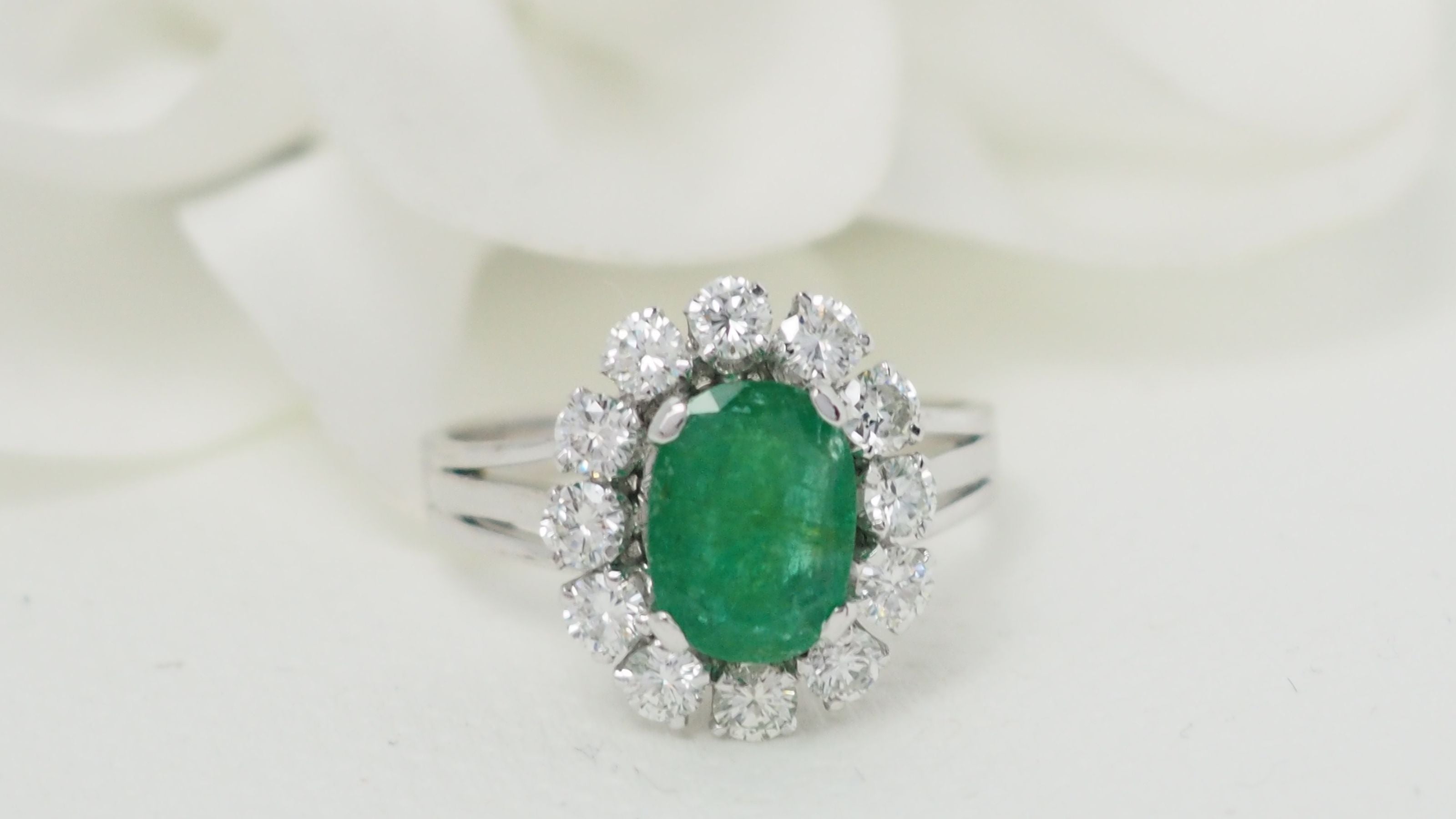 Bague entourage en or blanc, émeraude ovale et diamants