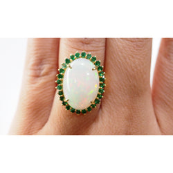 Oval ring in yellow gold, cabochon opal and emeralds 