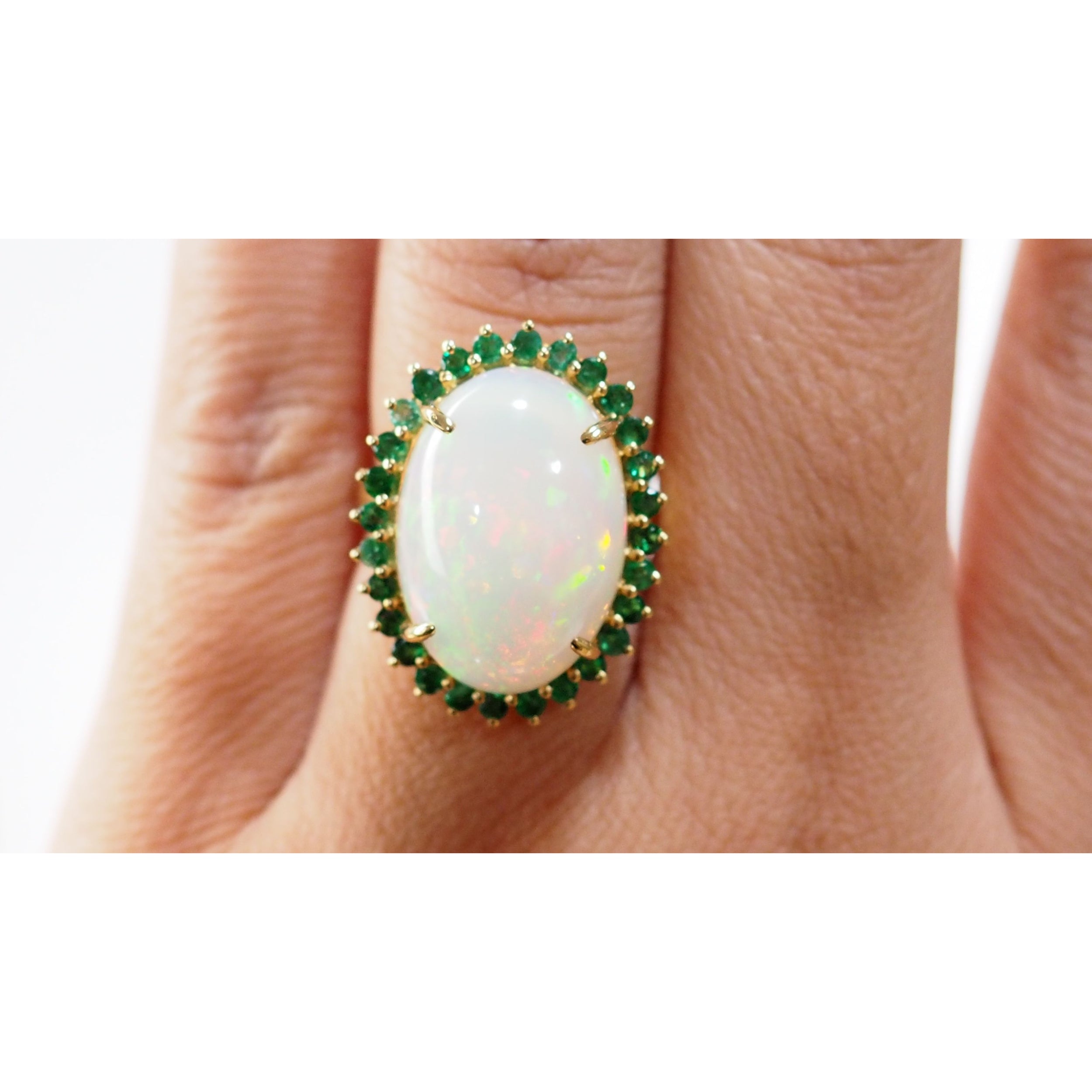 Oval ring in yellow gold, cabochon opal and emeralds 