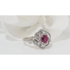 Bague entourage en platine, rubis ovale et diamants - Castafiore