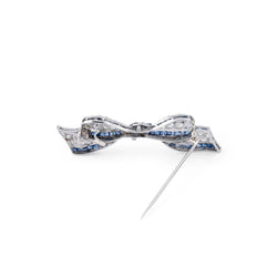 Broche nœud en platine Art Déco en diamant et saphirs calibrés - Castafiore