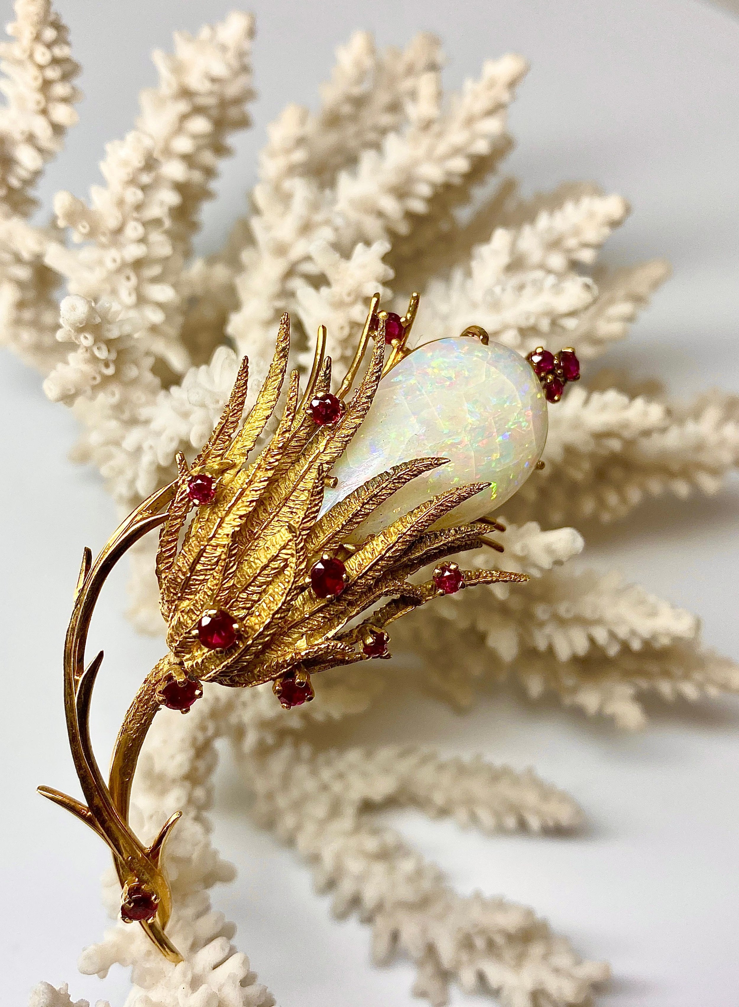 Broche en or 18 carats ornée d’une importante opale et de 13 rubis, vers 1960